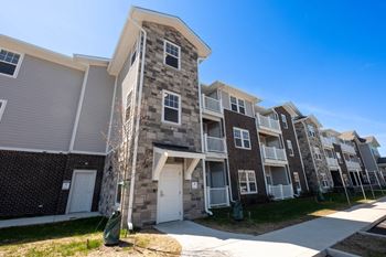 An apartment building with a stone exterior and white doors